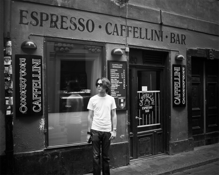 Caffelini i svartvit med en person på utsidan av cafeet